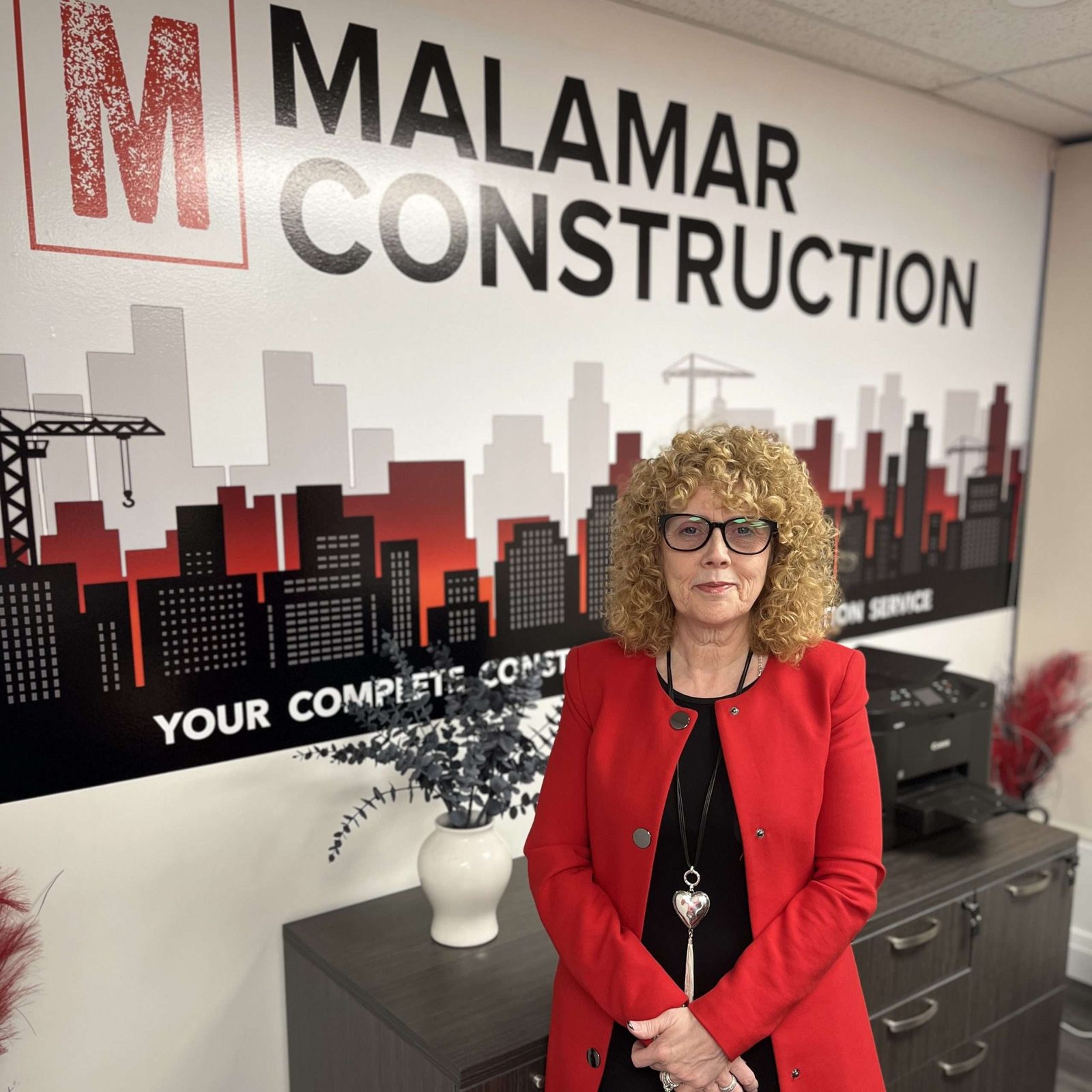 Gillian Cuthbert, Co-Owner and CEO, in a red blazer in the office